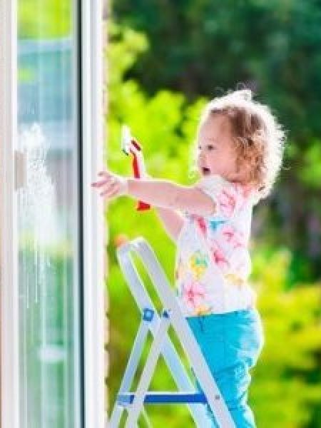 Image depicts a child cleaning a vinyl window.