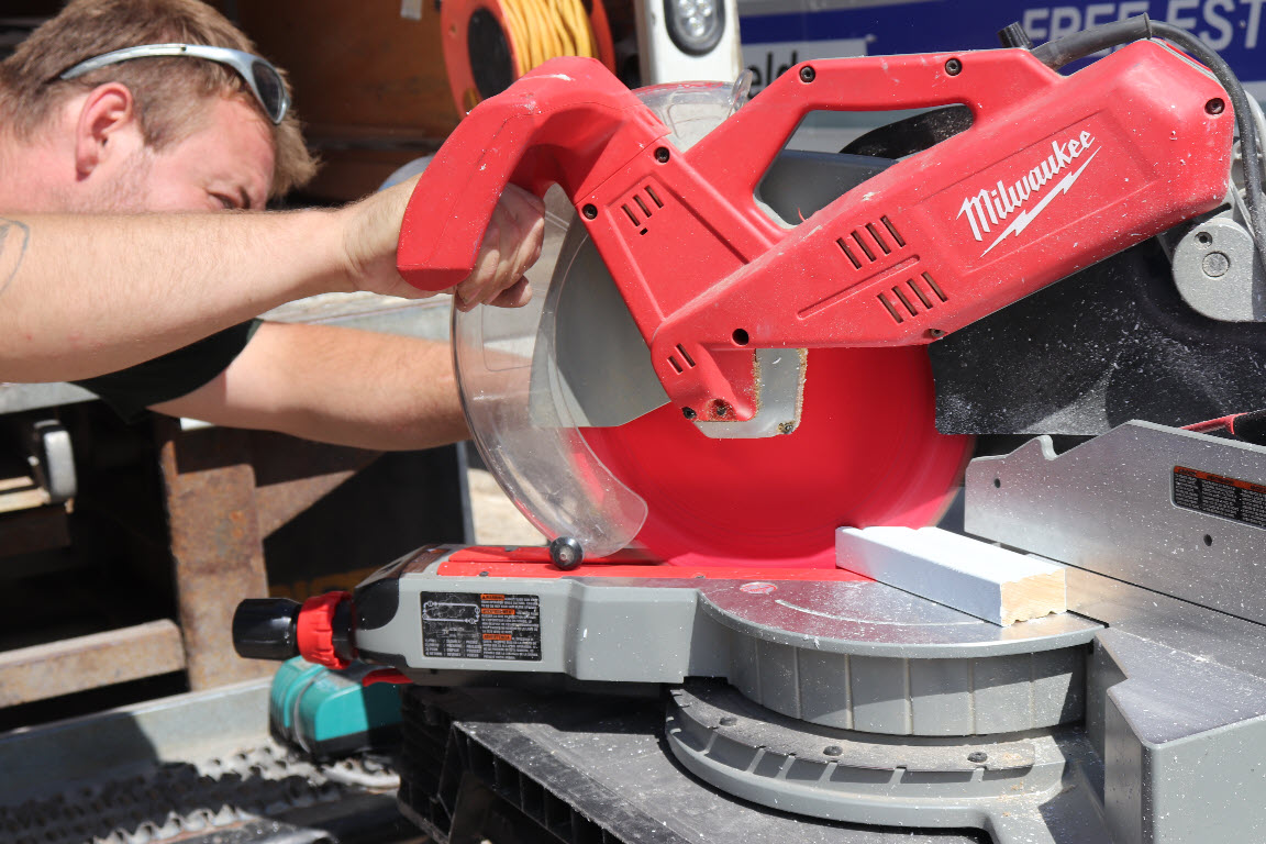 Image depicts a NorthShield employee cutting a vinyl window.
