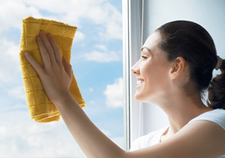 Image depicts a woman cleaning her window.