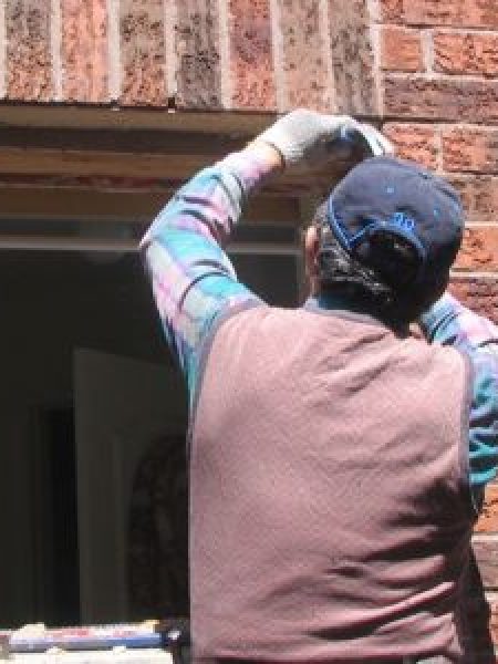 Image depicts a NorthShield employee doing a full framing window replacement.