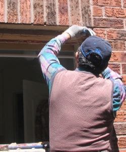 Image depicts a NorthShield employee doing a full framing window replacement.
