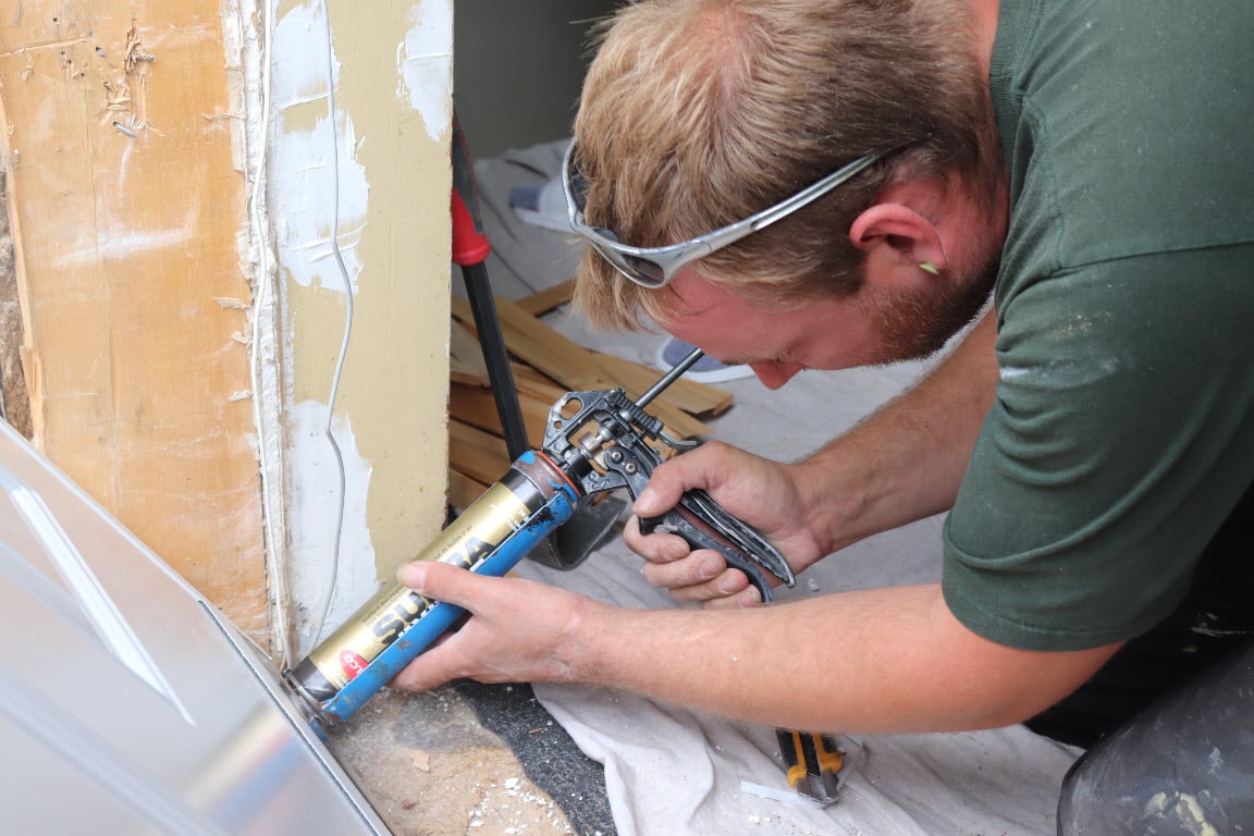 Image depicts a NorthShield employee installing a new window.
