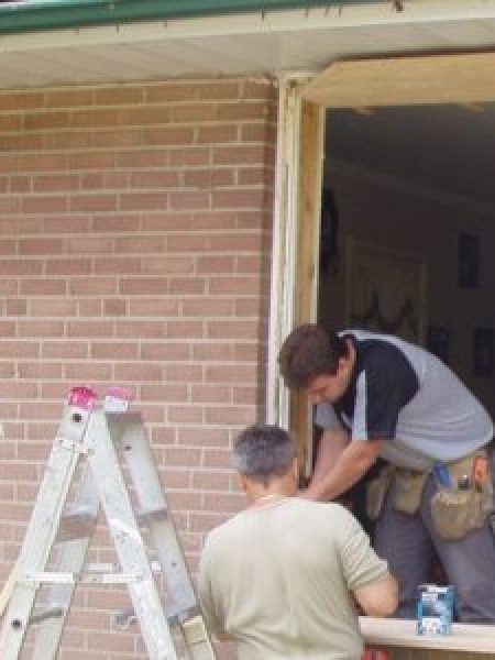 Image depicts NorthShield employees installing a new window.