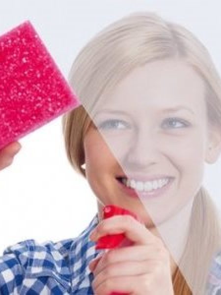 Image depicts woman cleaning a window.