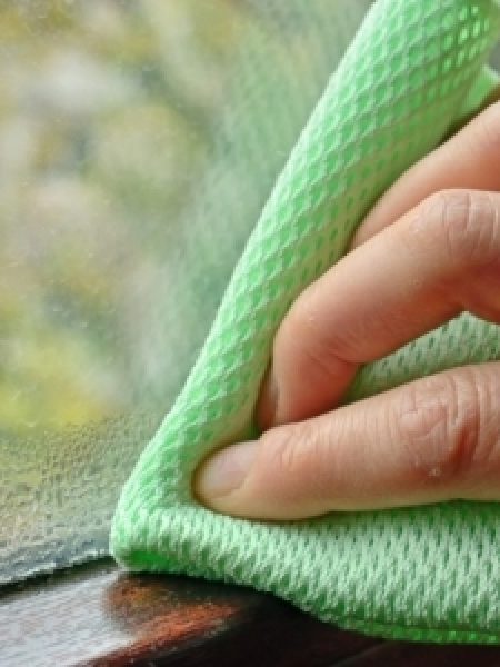 Image depicts someone cleaning a window.