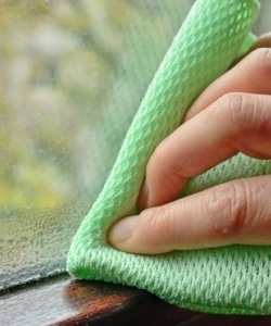 Image depicts someone cleaning a window.