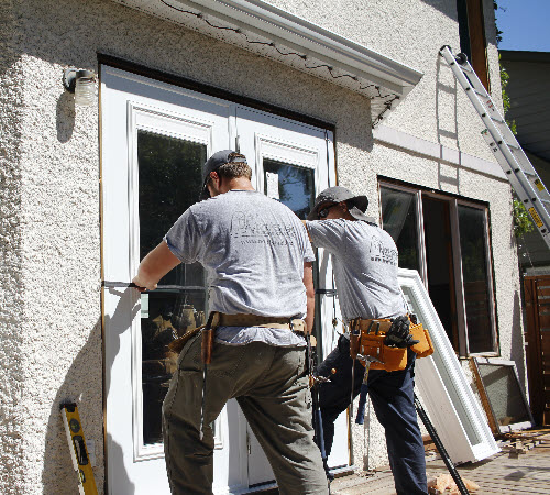 Image depicts two men installing sound insulation patio doors.