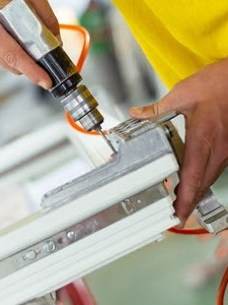 Image depicts a NorthShield window installer working on a triple pane glass window.