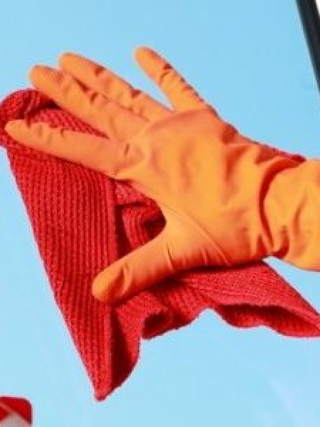 Image depicts someone cleaning a vinyl window.