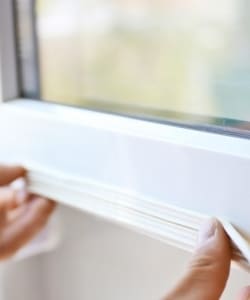 Image depicts someone weather-proofing their window.