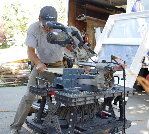 Image depicts NorthShield installer cutting a vinyl window.