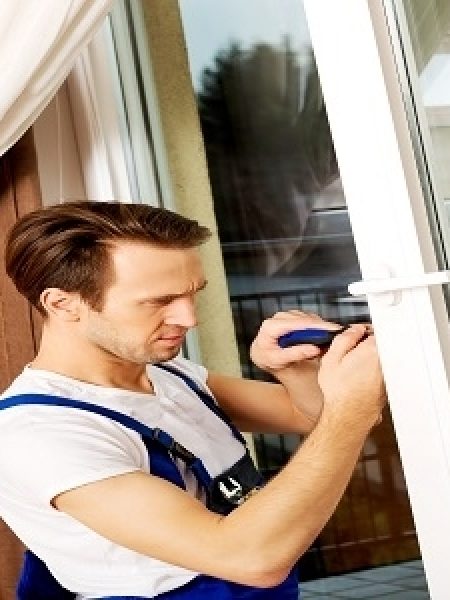 Image depicts a technician working on a vinyl window.