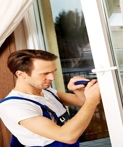 Image depicts a technician working on a vinyl window.