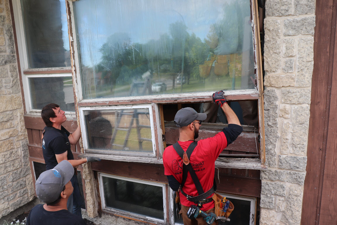 Image depicts NorthShield employees replacing a window.