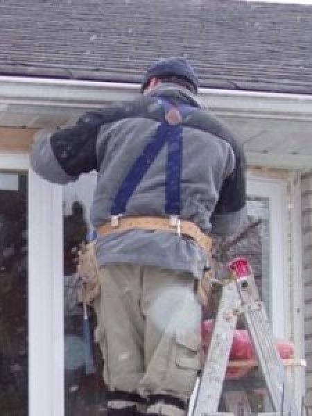 Image depicts a NorthShield installer doing a window retrofit.