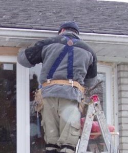 Image depicts a NorthShield installer doing a window retrofit.