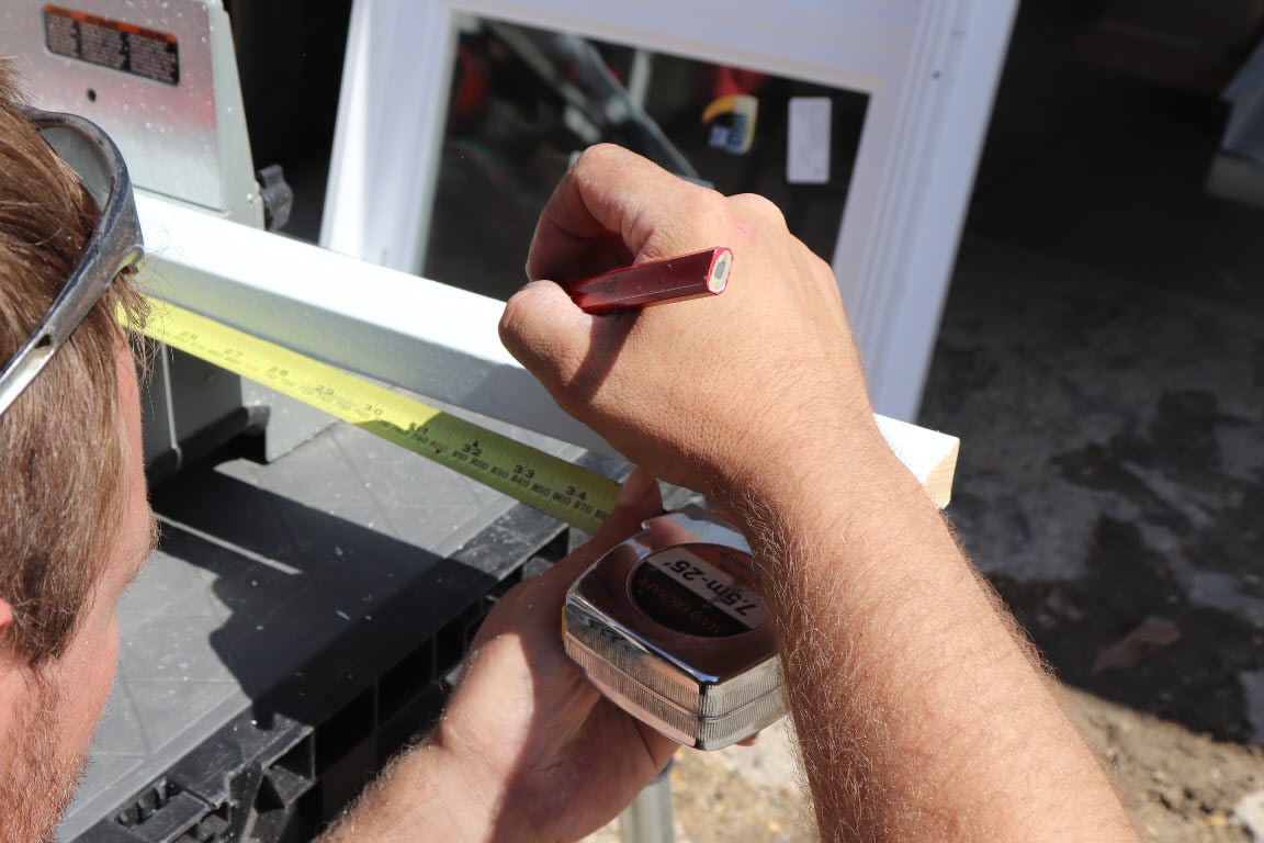 Image depicts someone cutting a new vinyl window.
