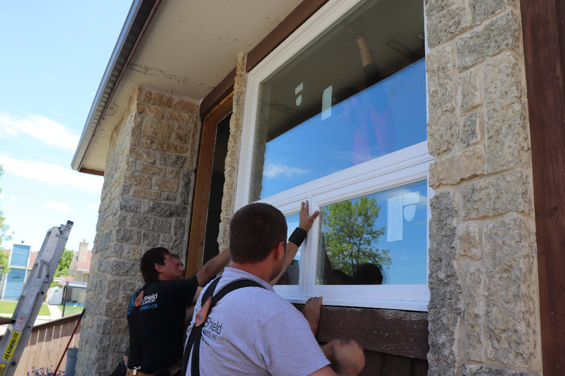 Image depicts NorthShield technicians installing a new window.