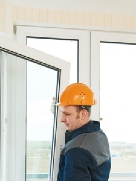 Image depicts a person installing a new window.