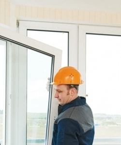 Image depicts a person installing a new window.