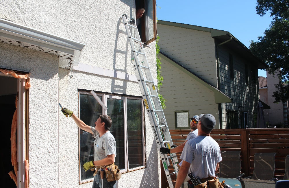 Image depicts NorthShield employees performing a window replacement.