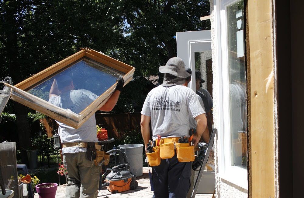 Image depicts technicians installing a new window.