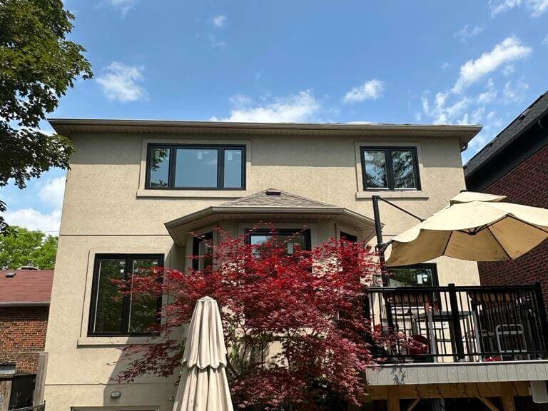 view of new black framed windows from backyard