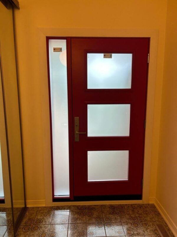 Red steel entry door with glass inserts and sidelite inside