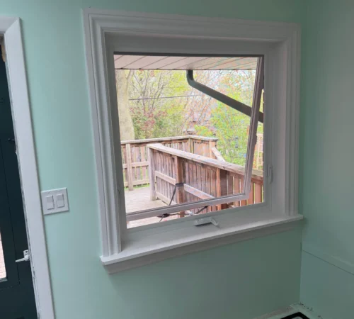 Interior view of a large fixed picture window with custom wood ledge finish