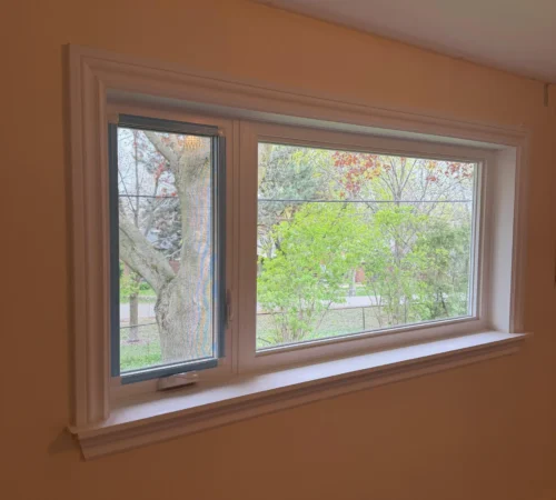 Interior view of offset casement and fixed window combination with wood ledge finish