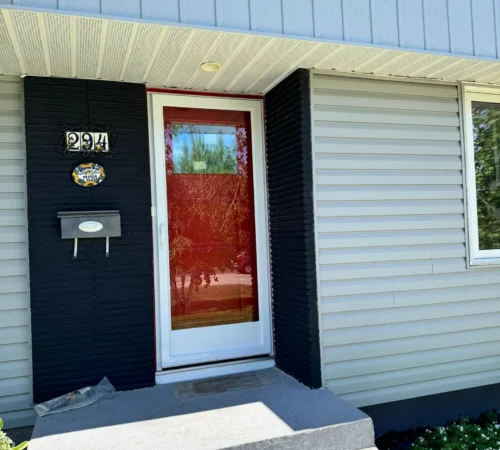 Modern red front entry door system with clear top glass and protective storm door in Calgary