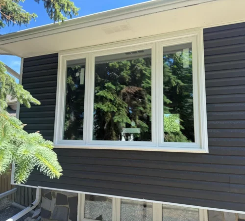 Large front window replacement on a Calgary home with operable side casement sections and a fixed centre pane