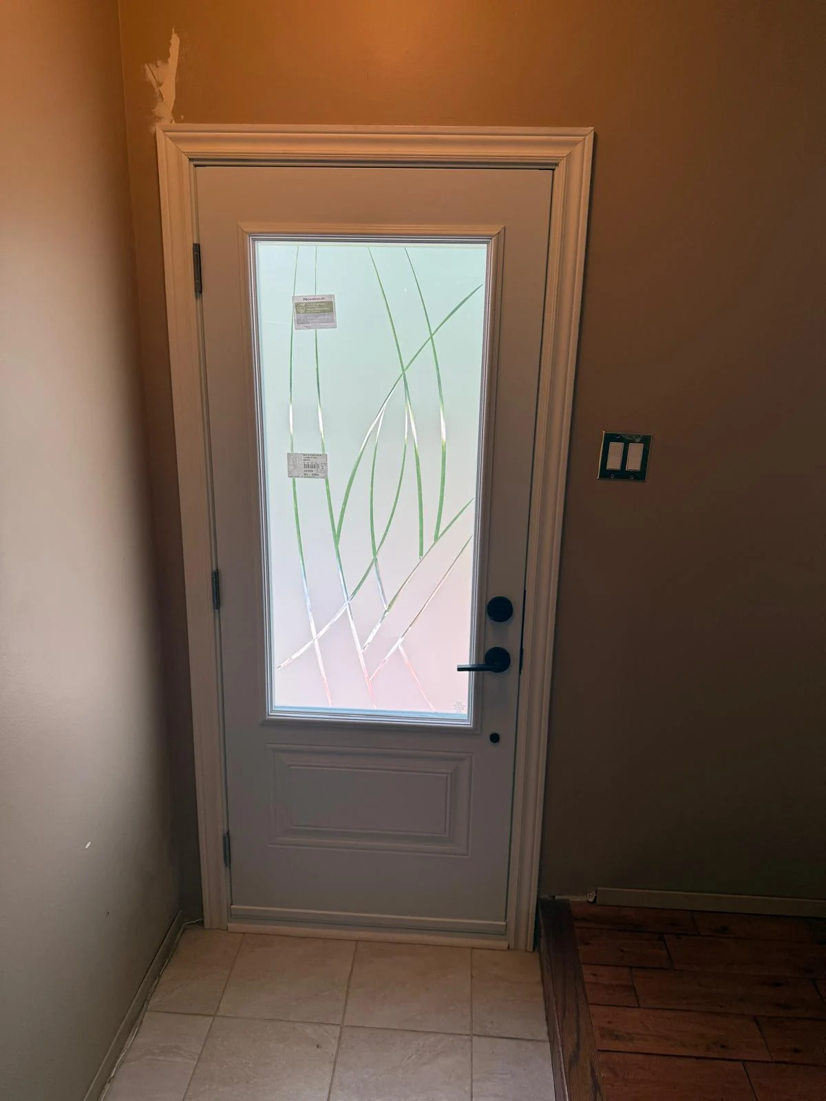 Decorative glass entry door interior showing how glass choice affects privacy and light.