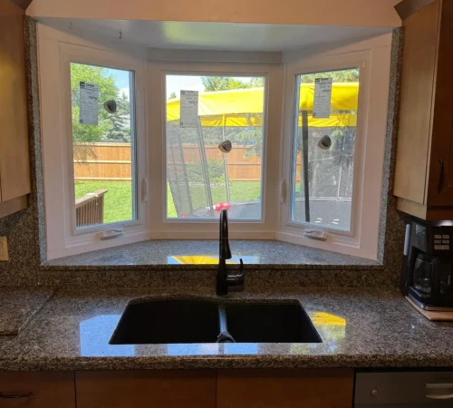 Kitchen bay window replacement with white vinyl interior casing