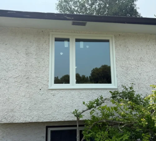 Calgary stucco home exterior with new white casement window