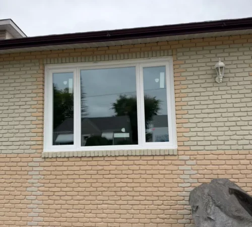 Front window combination with white casements on a brick wall