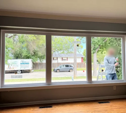 Inside view of the new three-section living room window with white vinyl trim