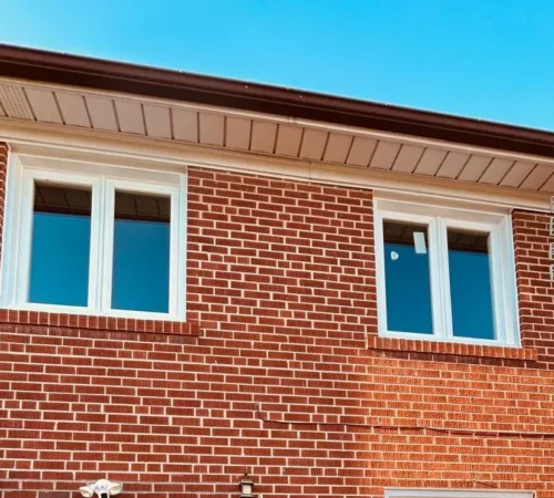 Two new white casement windows on the rear second floor of the house